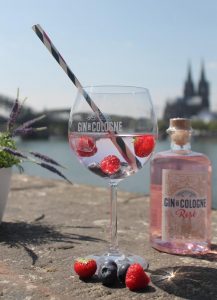 Gin-de-Cologne-Rosé-Flasche-Glas-Frueüchte-vor-Dom